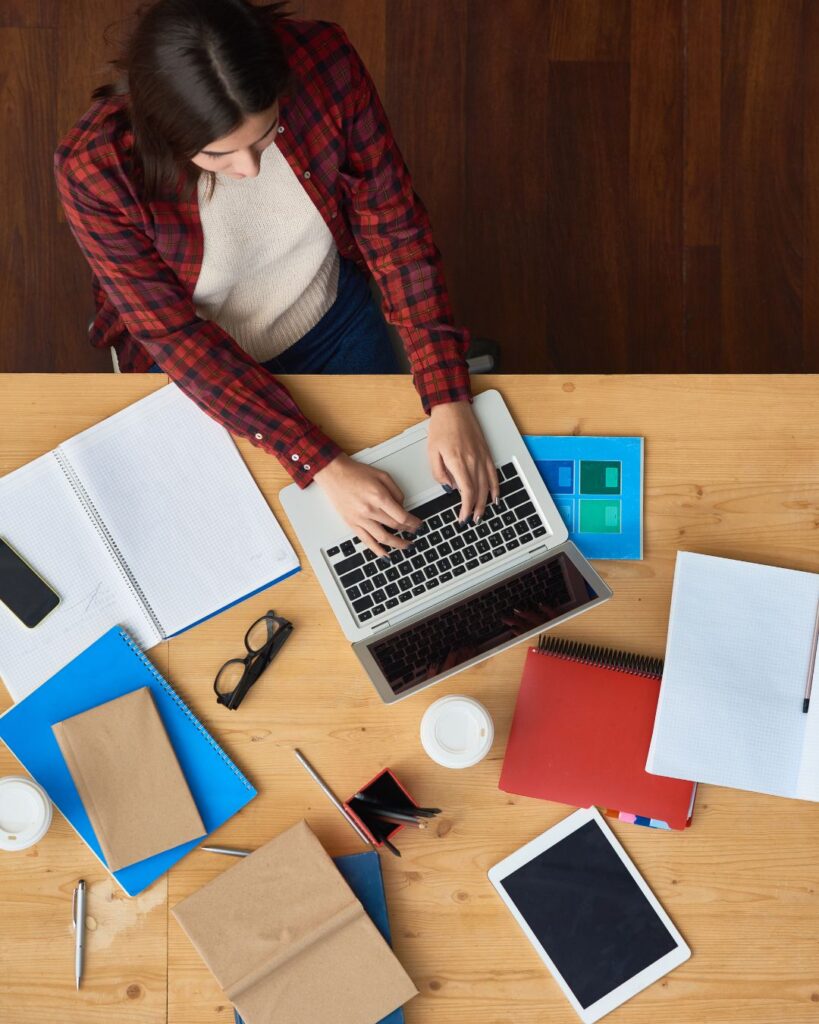 flat lay of a woman working on adapting to the world of ai on her website.