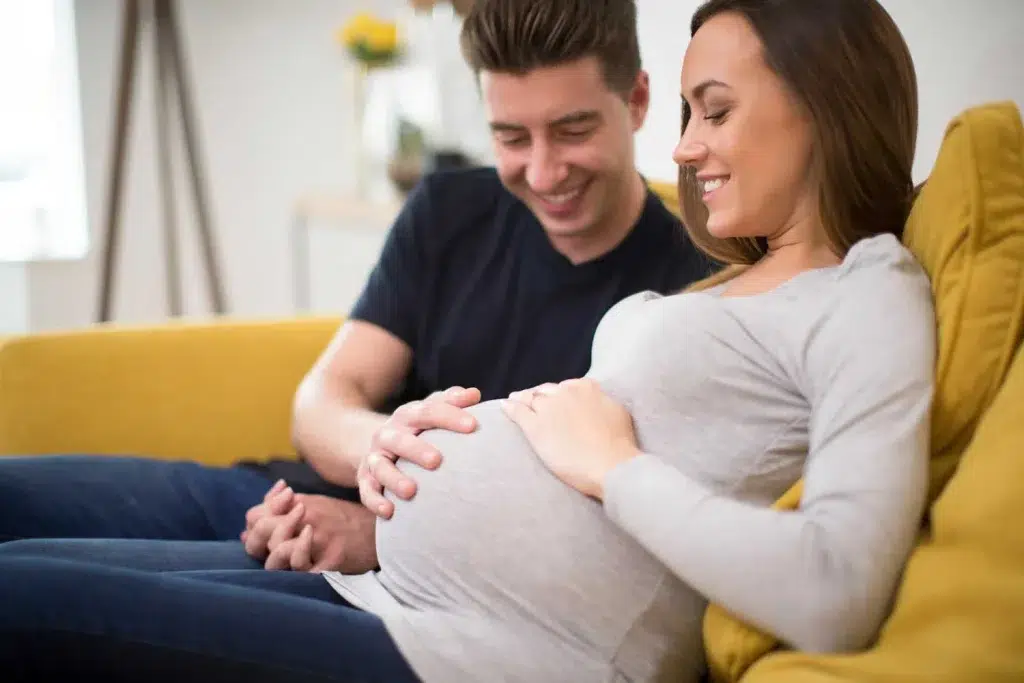 A man admiring the Women's pregnant belly.